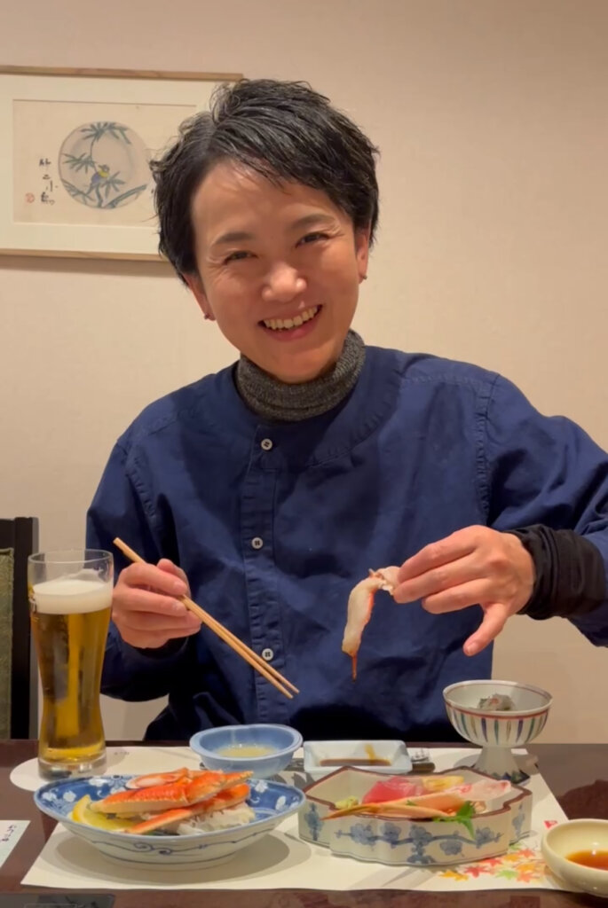 夫にごちそうになっているカニ料理をビールと一緒に堪能している写真