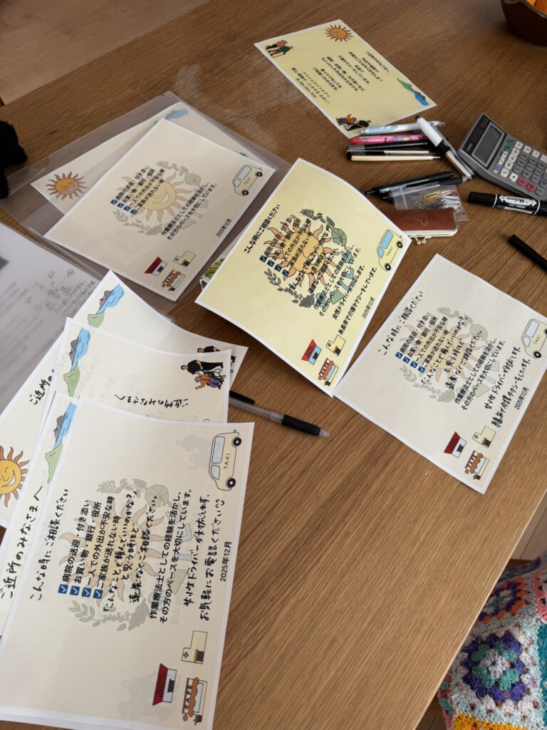 テーブルの上に下書きや筆記用具が散乱。チラシを作成している写真