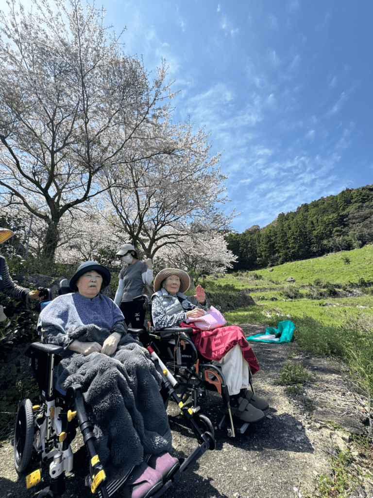 あおぞらと桜をバックにお客様のピース
